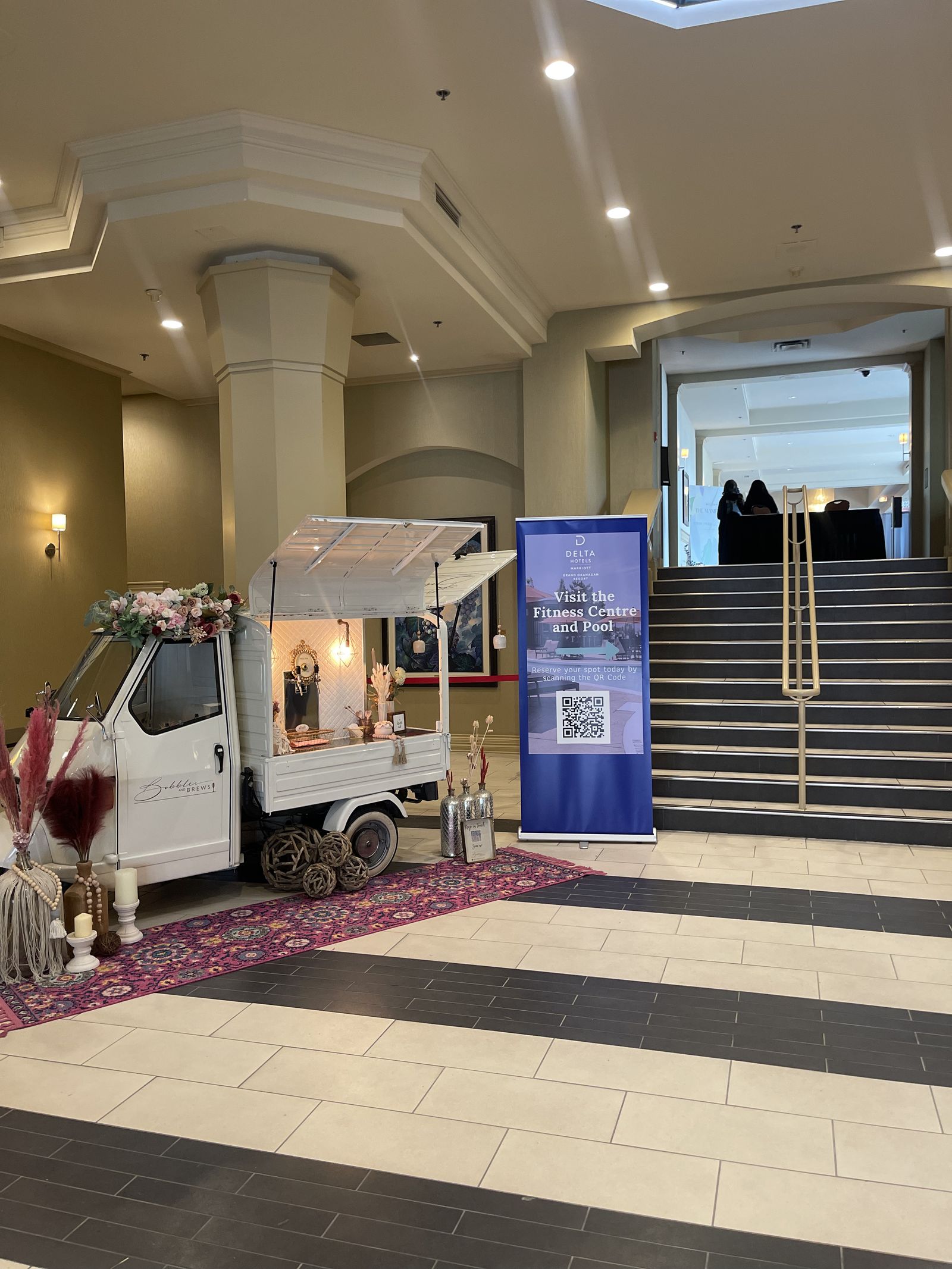 Bubbles and Brews mobile bar activation in a hotel lobby with a marble staircase