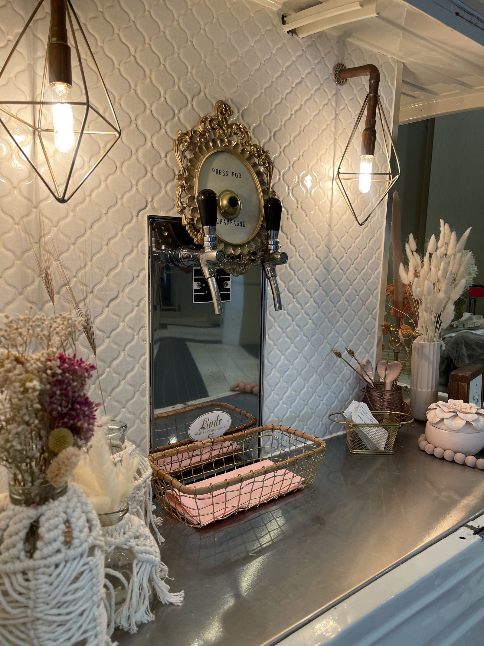 Vintage gold mirror reading 'Press for Champagne' above the prosecco tap system