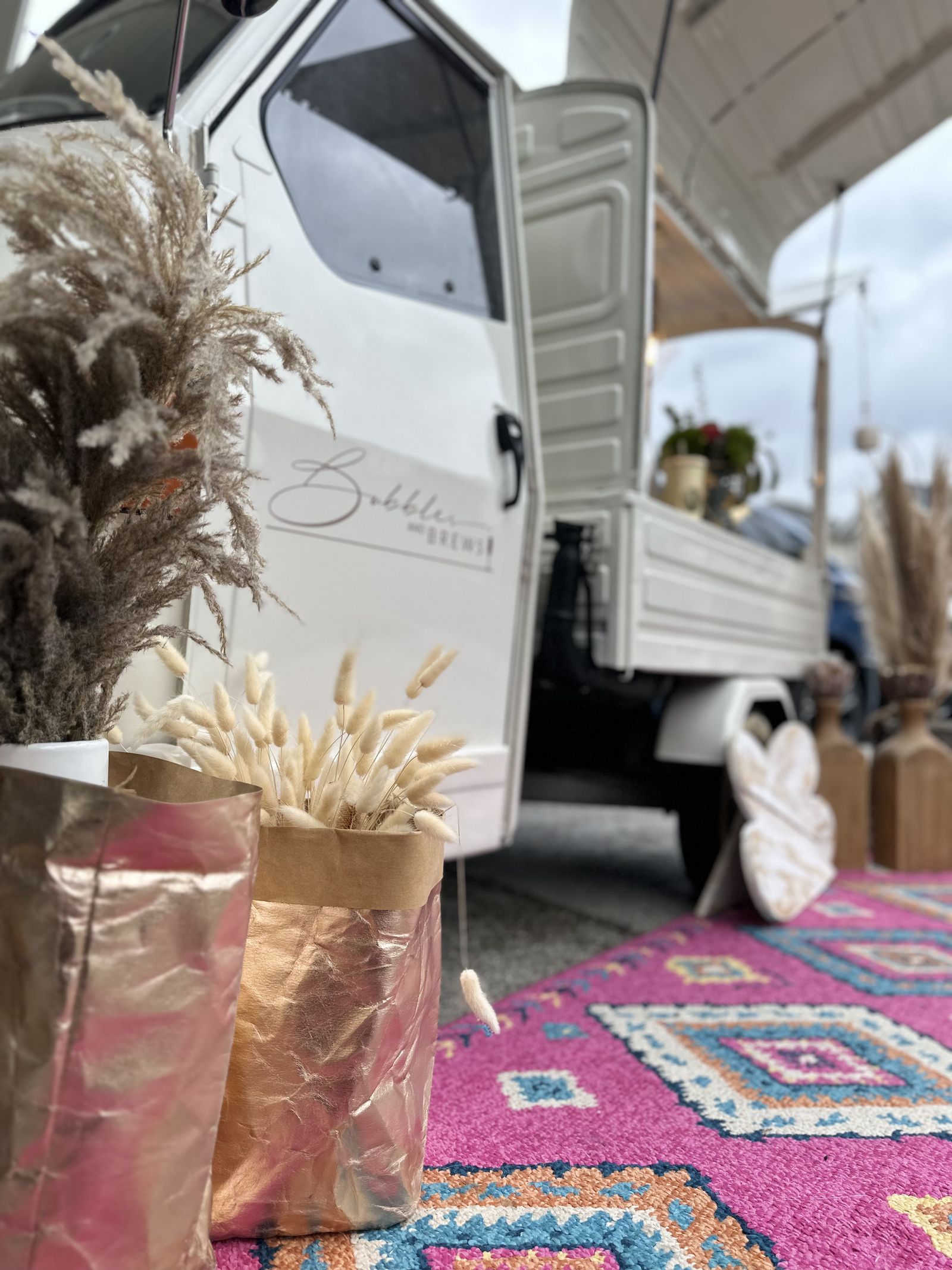 Styling detail of the prosecco truck with pampas grass in kraft paper bags