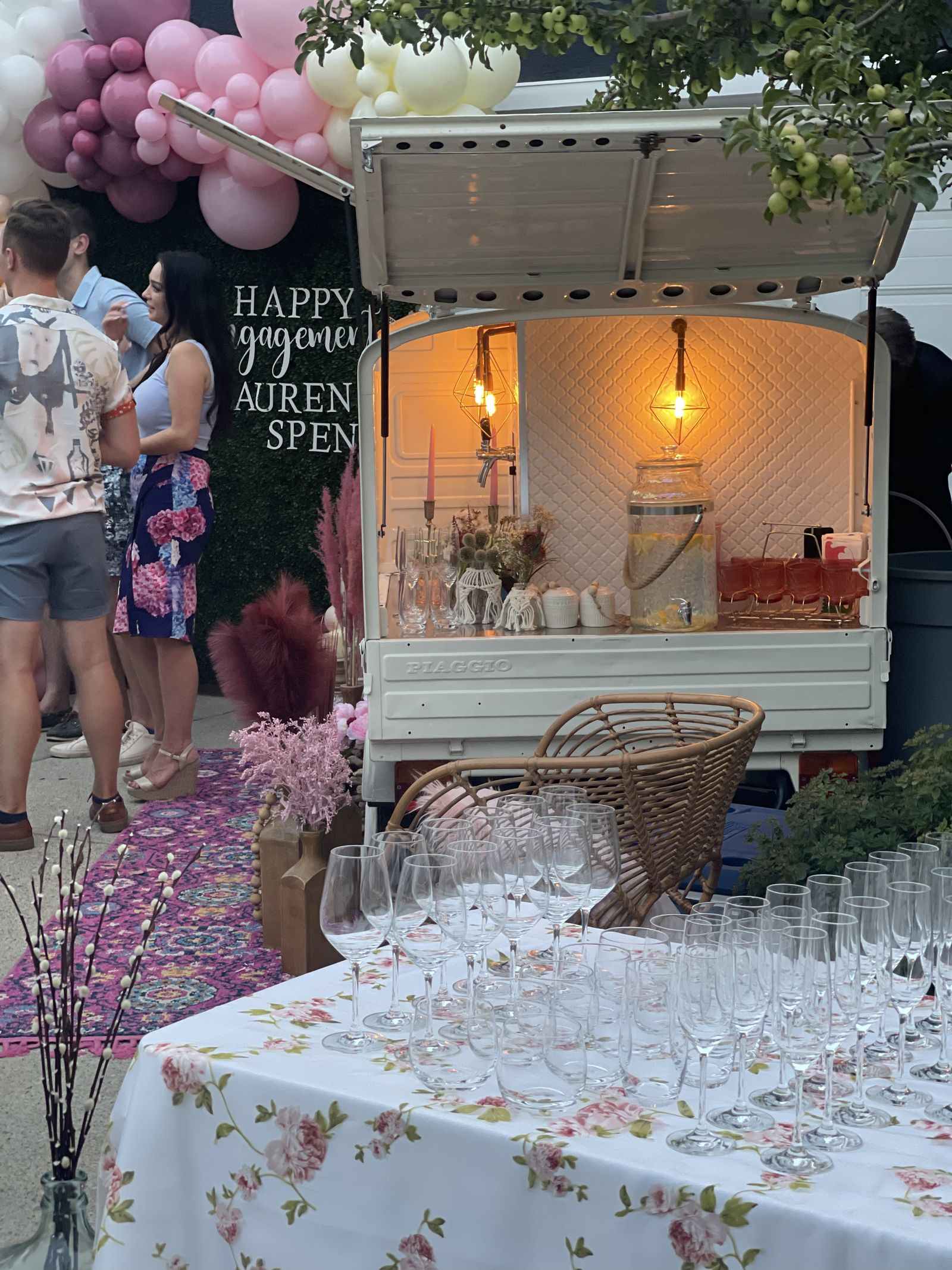 Guests gathered around the Calgary mobile bar at an engagement party, champagne glasses set for toasting