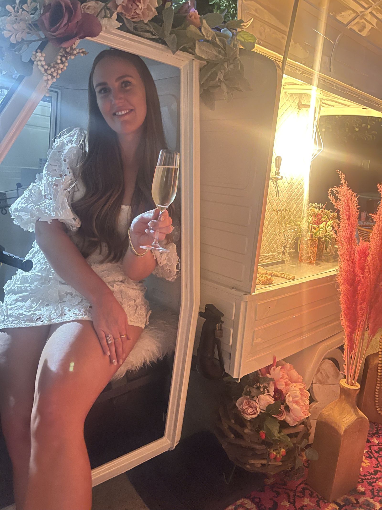 Golden hour portrait of a guest seated in the Bubbles and Brews Calgary mobile bar holding a glass of prosecco