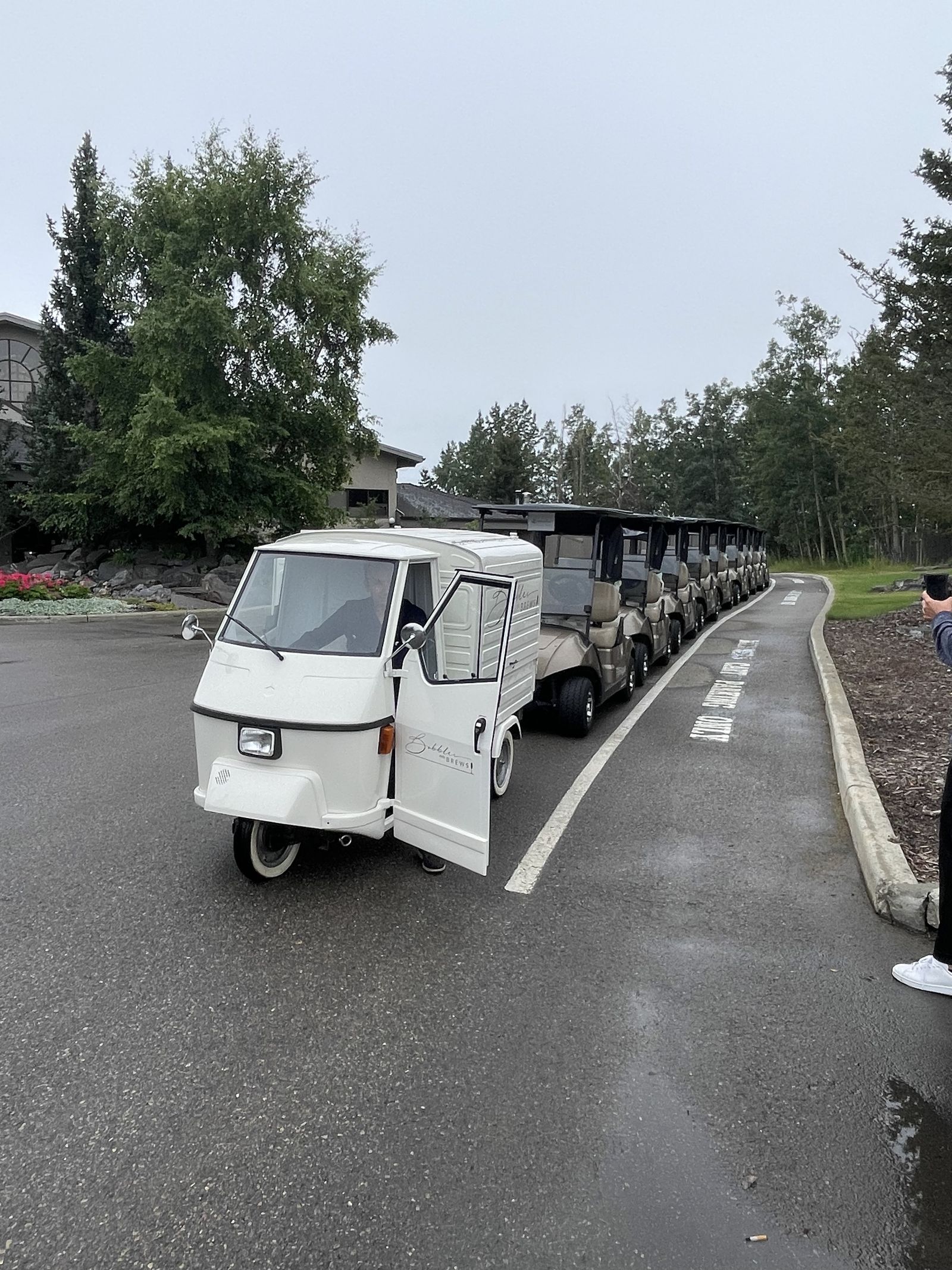 Bubbles and Brews mobile bar lined up with a row of golf carts at an Alberta golf tournament