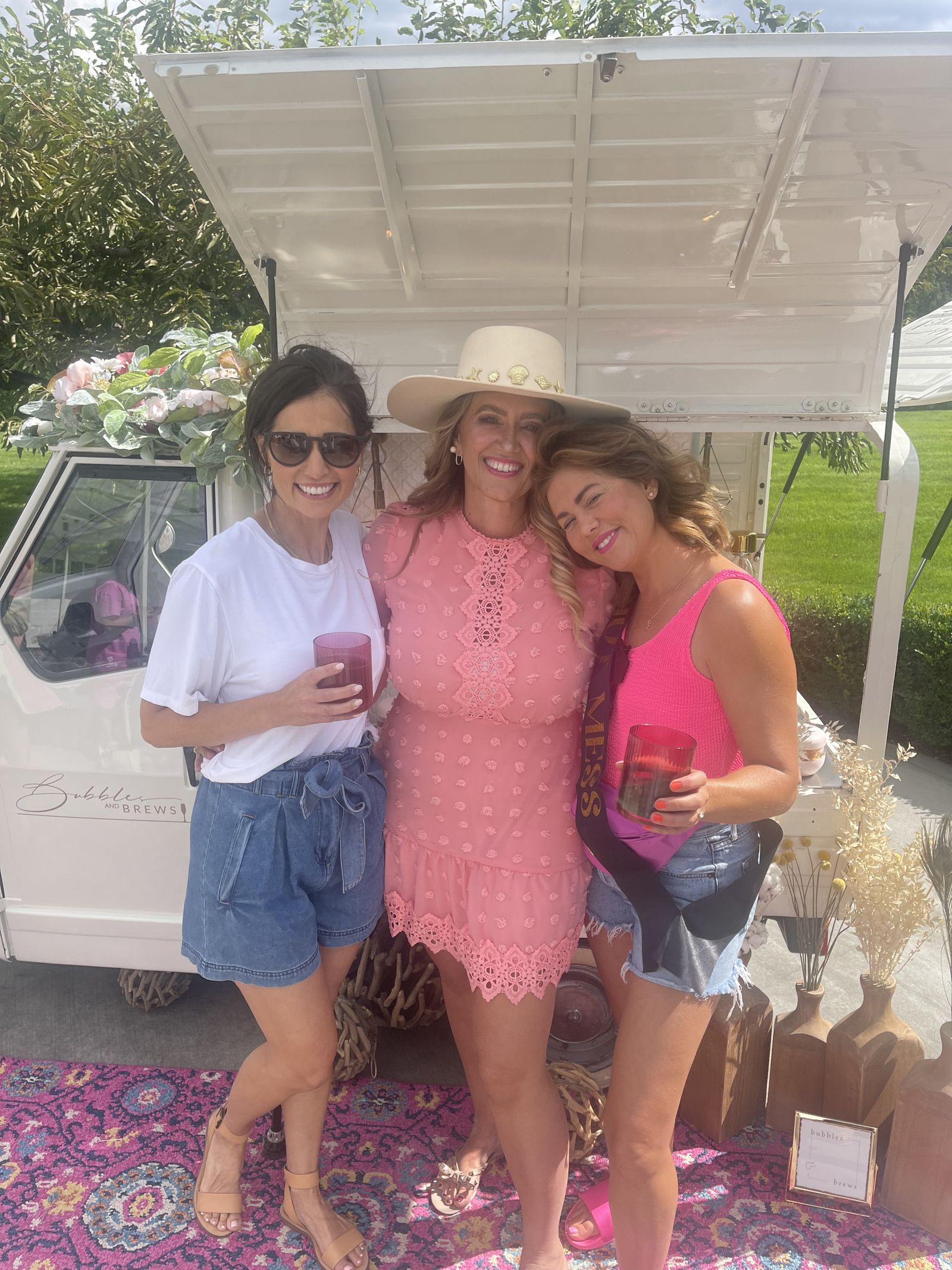 Guests celebrating at a bachelorette party in front of the Bubbles and Brews prosecco bar