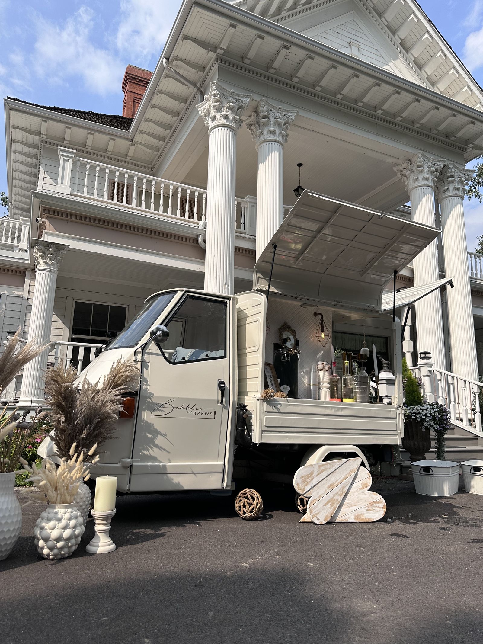 Bubbles and Brews prosecco bar parked in front of a grand white colonial-style mansion with columns