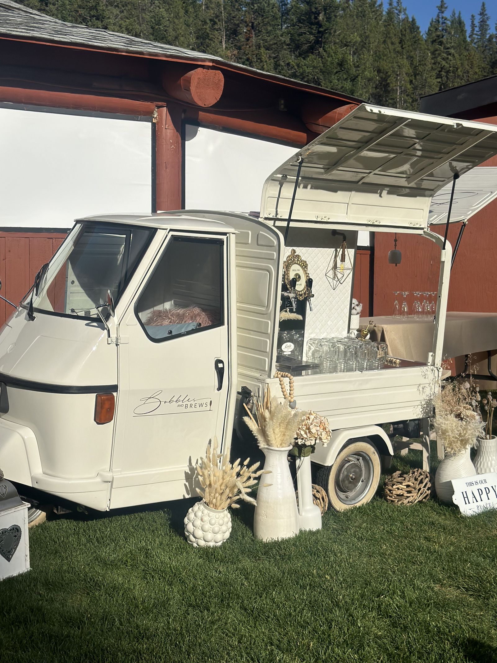 Bubbles and Brews mobile bar parked in front of a rustic timber-frame building at an Alberta event venue