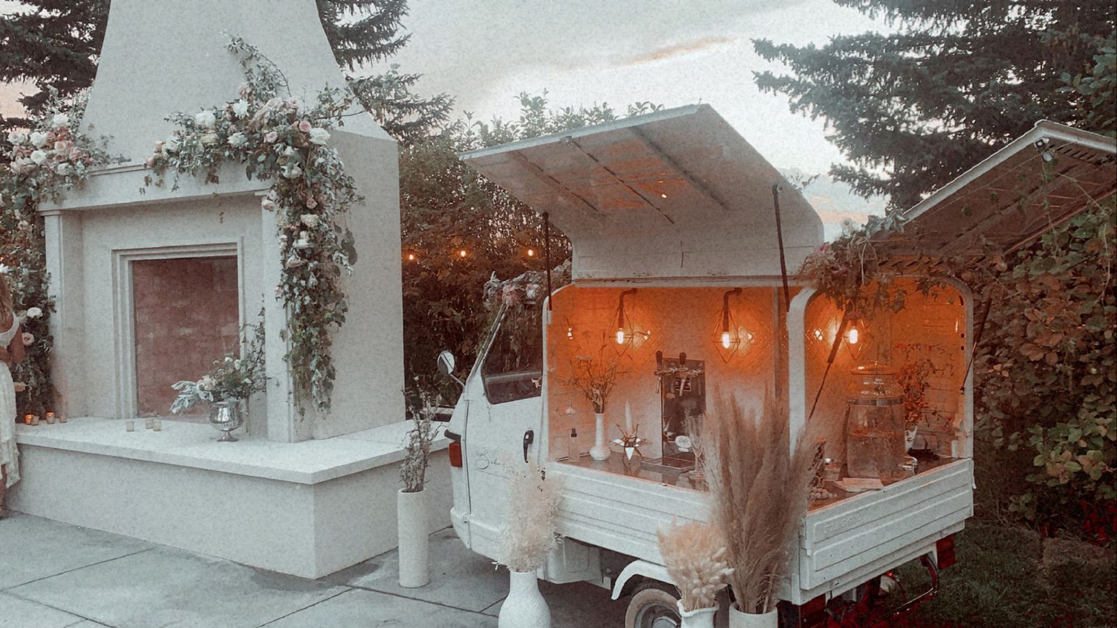 Bubbles and Brews mobile bar at dusk beside an elegant outdoor fireplace at a Calgary estate venue