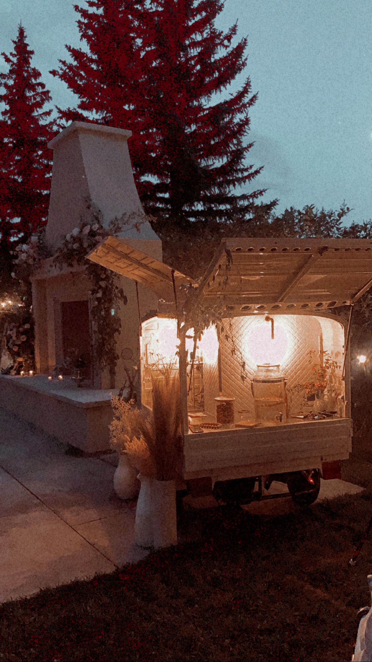 Moody dusk view of the mobile bar at a Calgary estate venue with a stylized film-grain look
