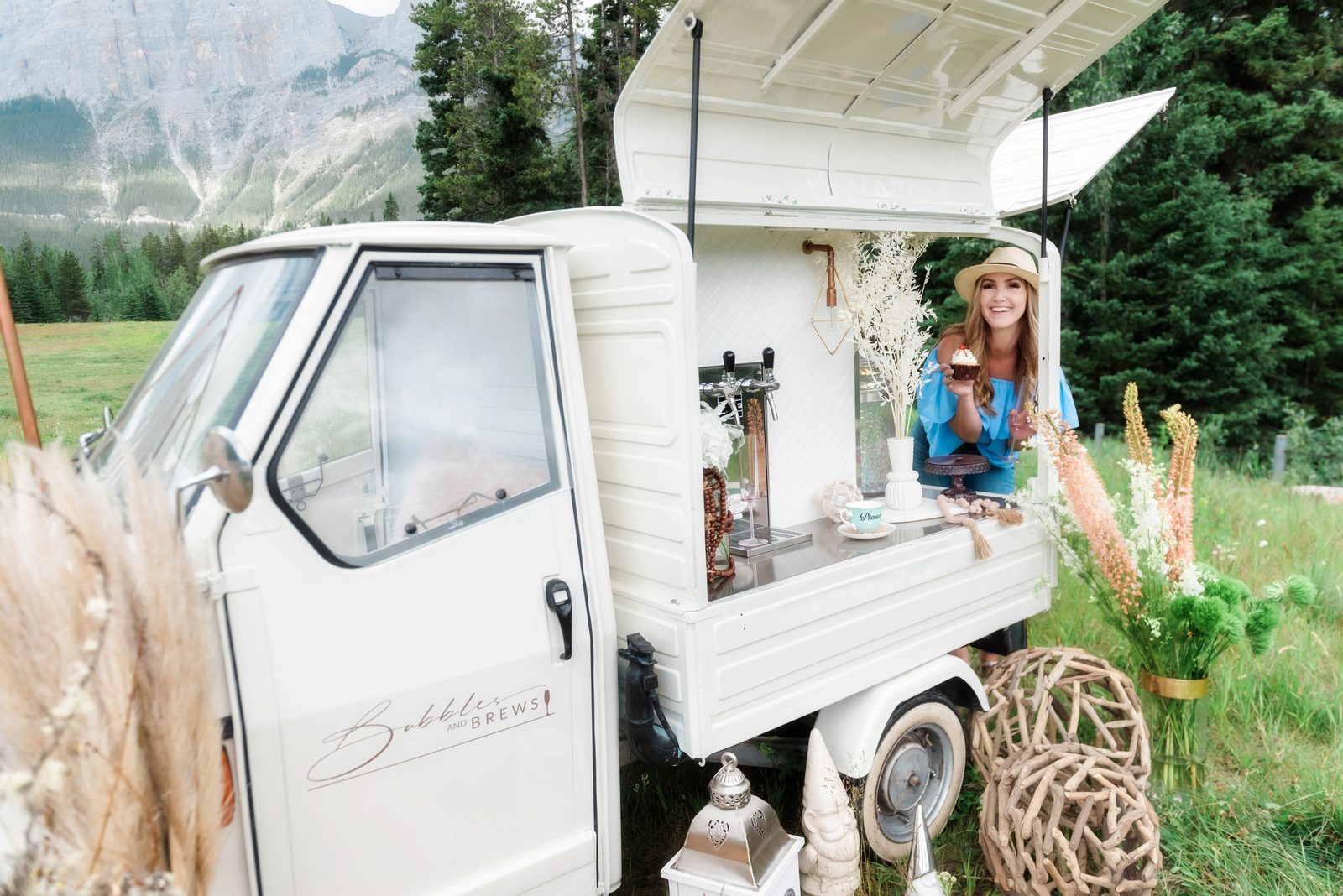 Bubbles and Brews mobile bar styled with dried florals against a Canmore mountain backdrop