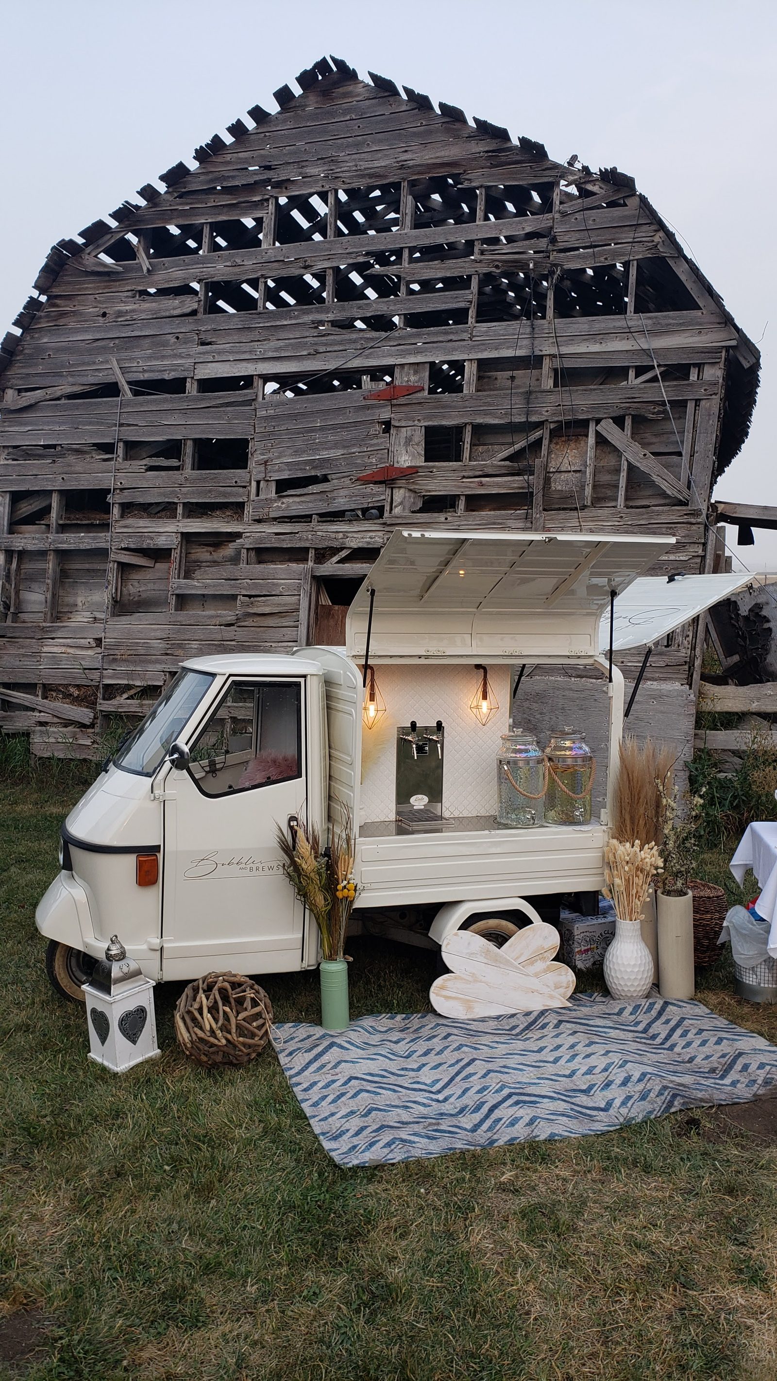 Bubbles and Brews prosecco bar parked in front of a weathered rustic barn near Okotoks, Alberta