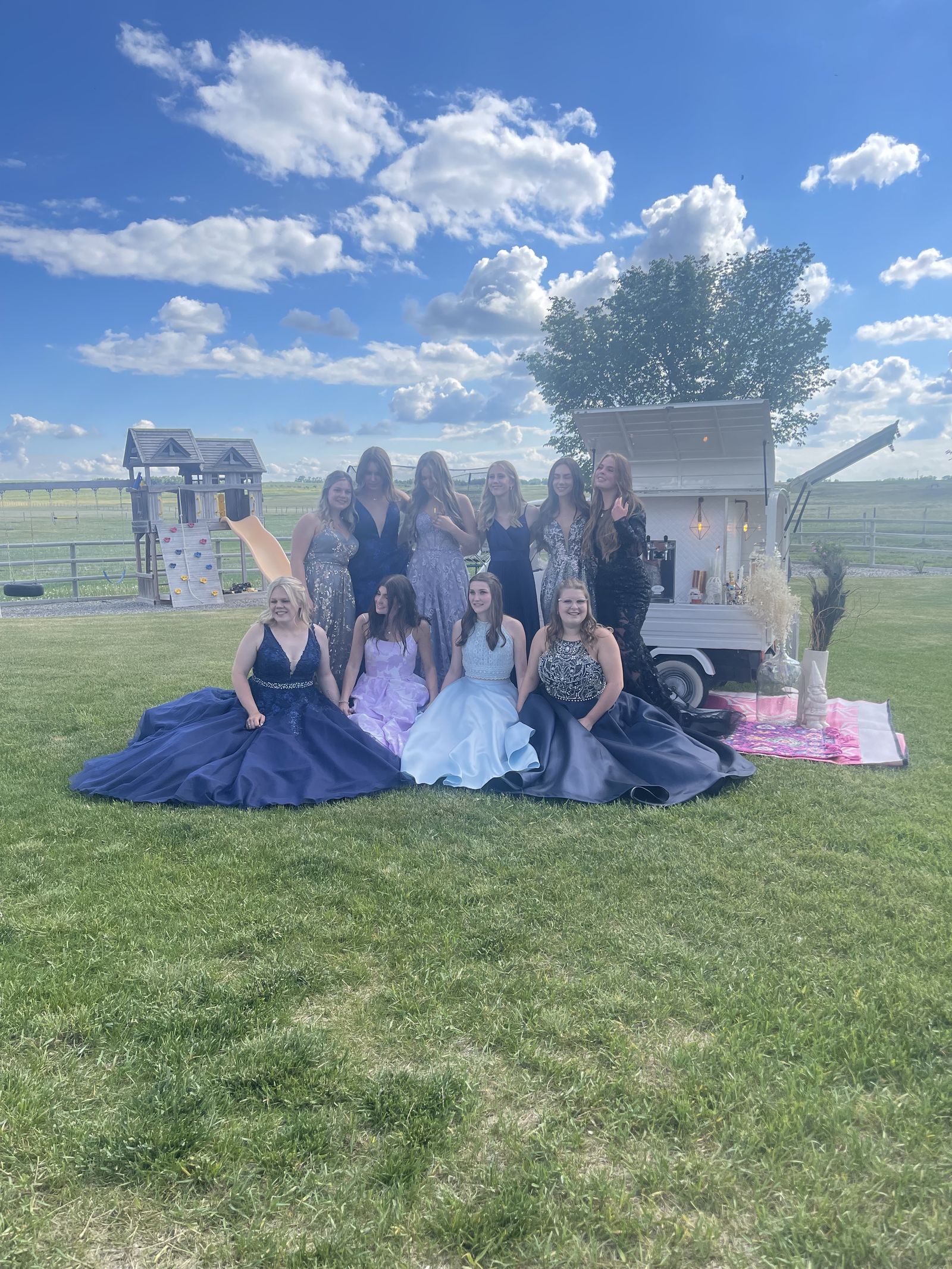 Bridesmaids posed in front of the Bubbles and Brews mobile bar at a Calgary backyard wedding