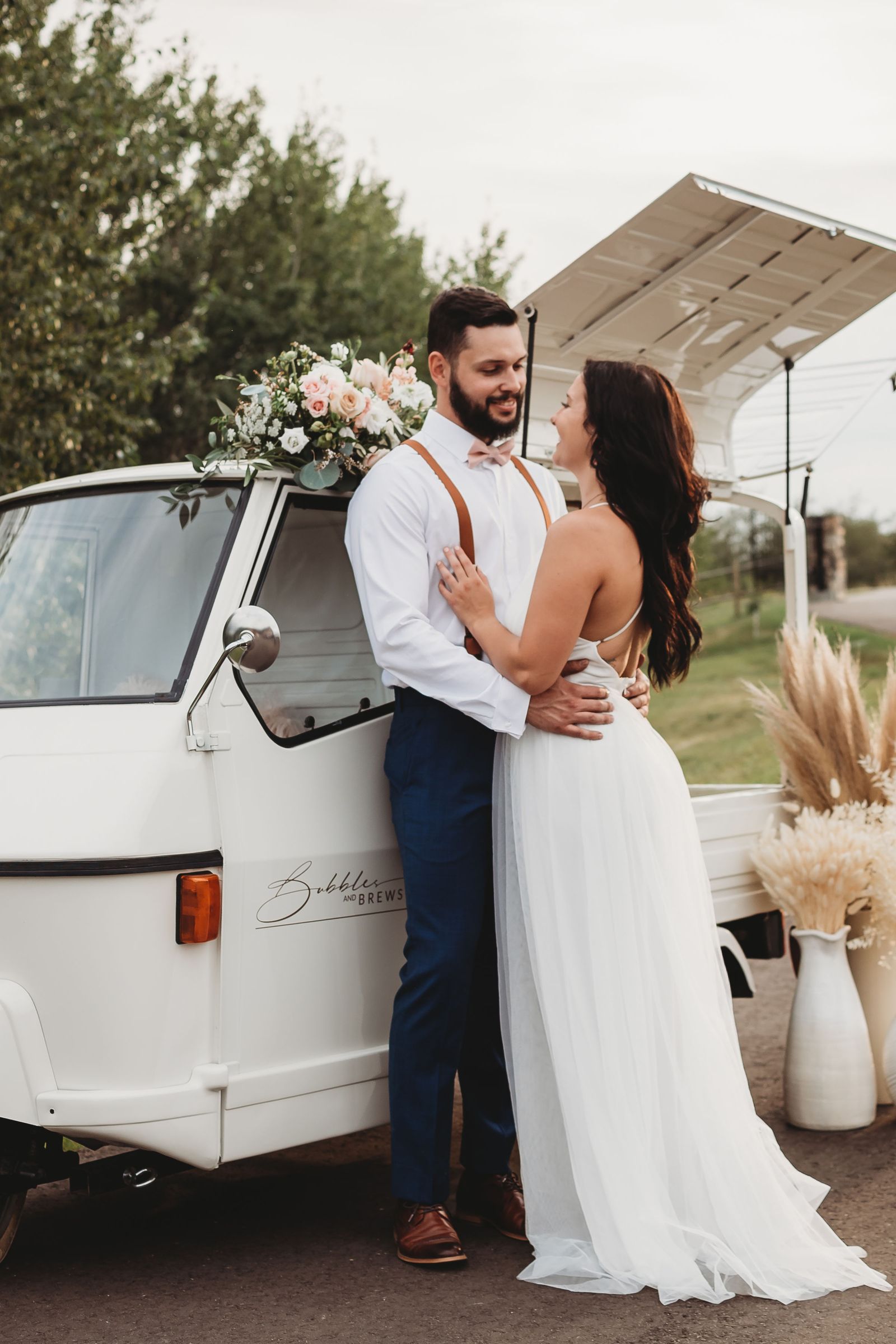 Wedding couple embracing beside the Bubbles and Brews Calgary mobile bar, professional photography