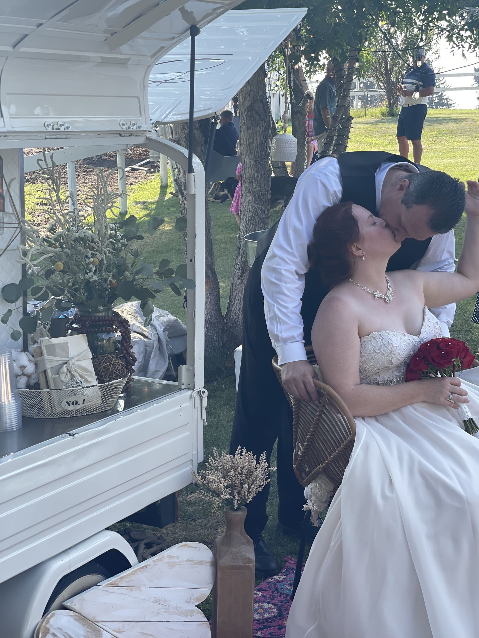 Wedding couple sharing a kiss beside the Bubbles and Brews prosecco bar