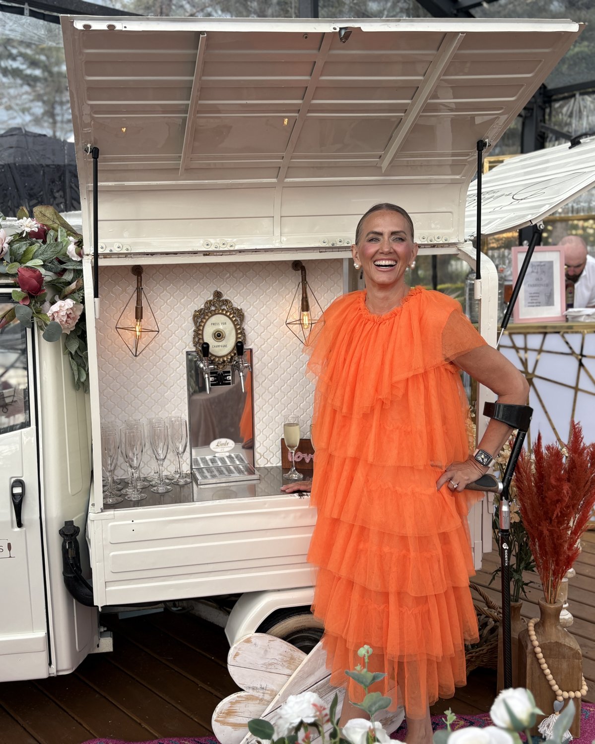 Cindy Luterbach, founder of Bubbles and Brews Canada, laughing behind the prosecco taps of the vintage Calgary mobile bar